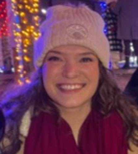 Smiling person, winter hat, lights.